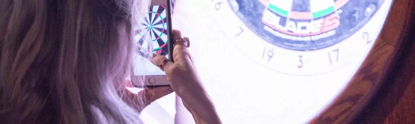 persons taking photo of electronic dart board