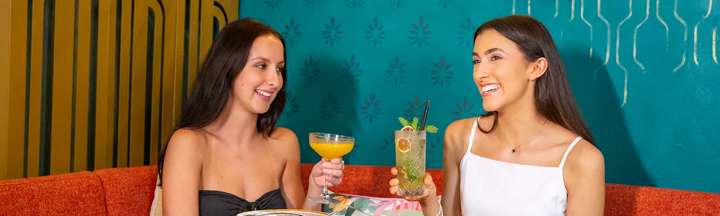 two women drinking a cocktail