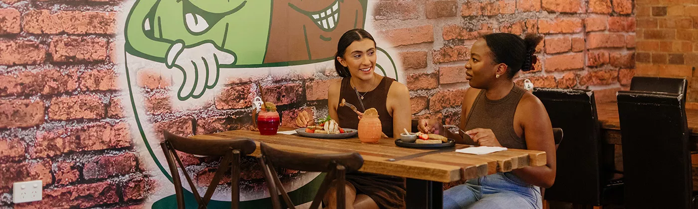 Two females enjoying breakfast and juices at Bare Beanz Cafe