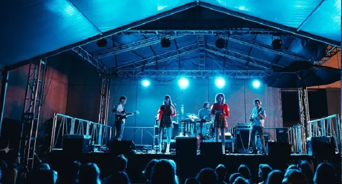 5 piece band playing on a stage 