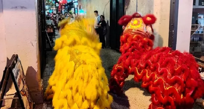 two  chinese lion dance performers  facing  into Bakery lane