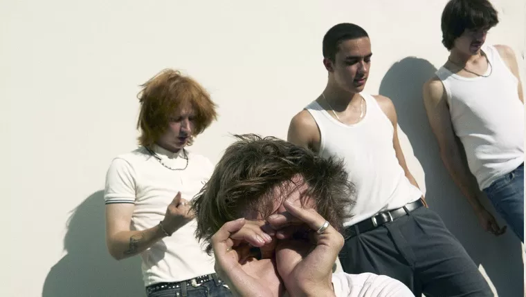 4 persons wearing black pants and white tops against white wall