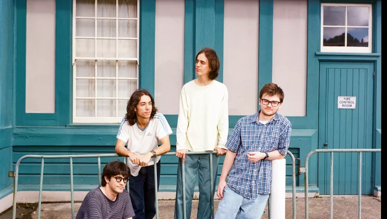 4 people stood by a fence outside a building