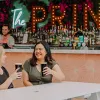 Two women (blonde and brunette) cheersing a beer at The Prince Consort